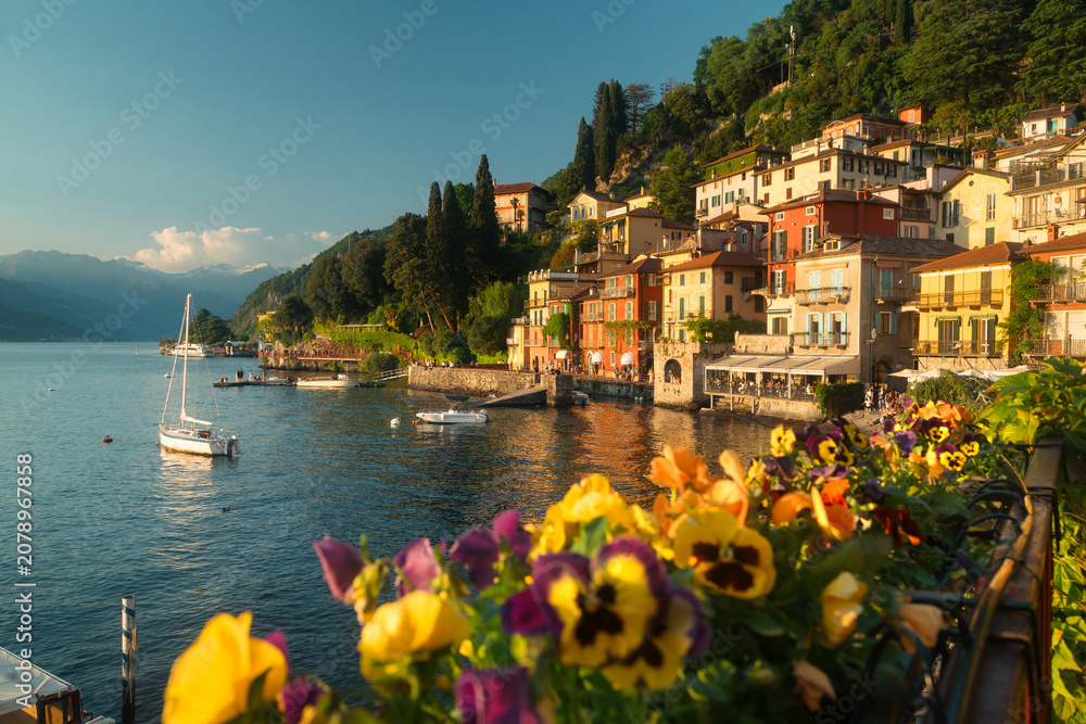 Obraz premium Historic town of Varenna along the shores of famous Lago di Como illuminated in golden evening light at sunset, Lombardy, Italy