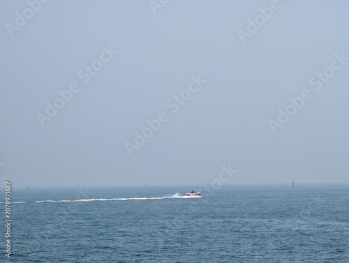 Photos Minimalist Seascape with A Distant Soft Pink Boat Cruising On Calm Grey-Blue Oce