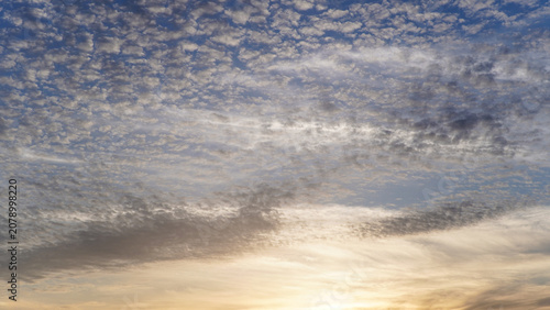 Bild auf Leinwand Dynamic Altocumulus Clouds and Streaks Illuminated by Golden Sunset Light