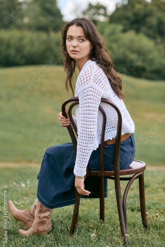Obraz na plátně Charming young woman enjoys a peaceful moment in the park wearing stylish attire