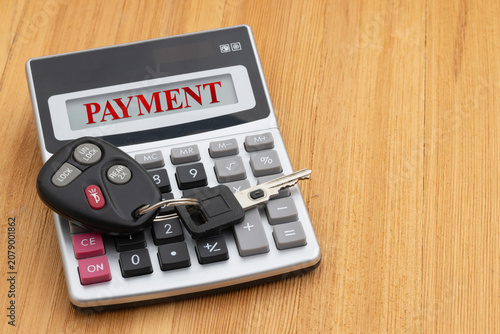 Payment test with car keys and calculator on wood desk
