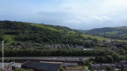 Aerial drone view of Mytholmroyd railway station in Calderdale West Yorkshire showing surrounding streets and hills