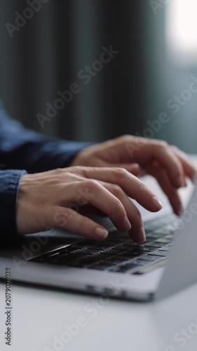 Woman works on a laptop keyboard in a candid setting during the day.