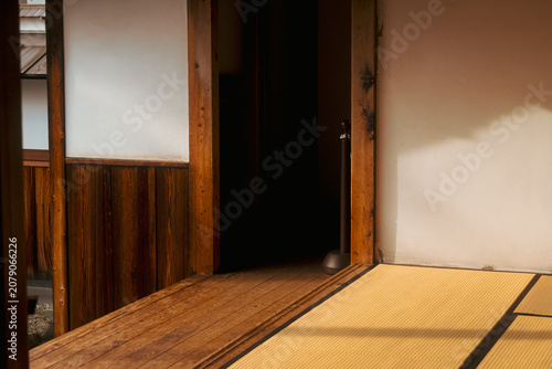 фотографія Sunlight casting shadows on tatami mats and wooden corridor of a traditional Jap