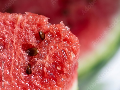 Close-up of a juicy red watermelon slice with seeds.