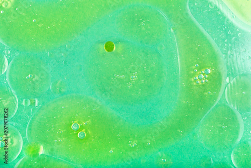 Water background with oil stains. Water background with colorful oil stains that create unique patterns and textures, showcasing vibrant hues of green with bubbles and smooth surfaces