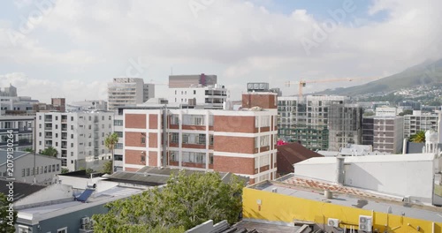 Camera is starting slow left pan on rooftop, holding red brick block centered and revealing skyline