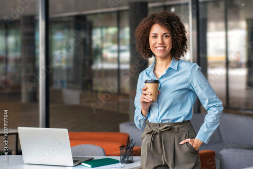 Smiling African American corporate worker holding coffee