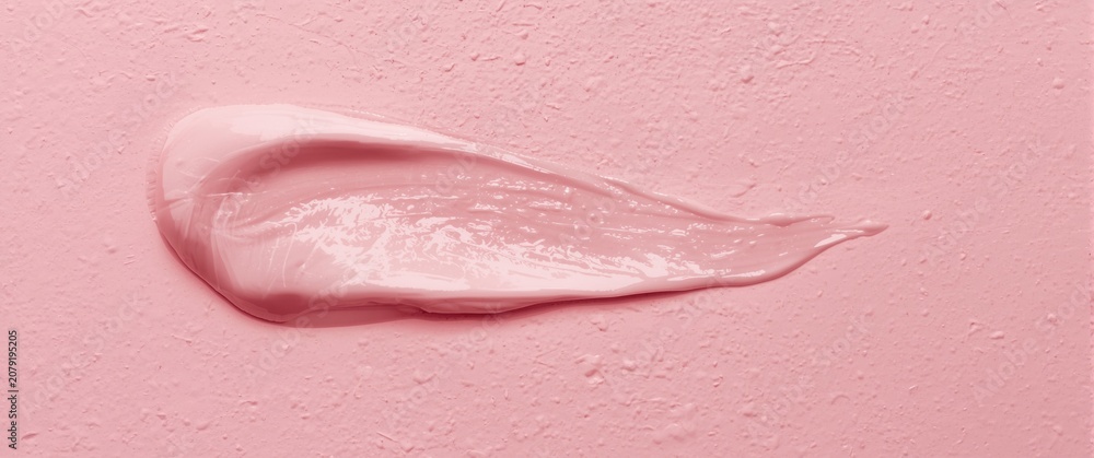 Fototapeta premium Light pink cream smeared on a textured surface
