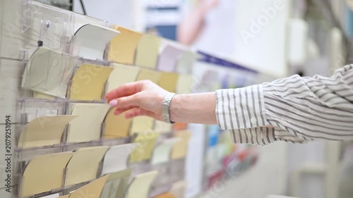 A hand reaches out to choose color samples from a display board in a creative workspace. The individual appears to be engaged in planning for design projects or home decoration