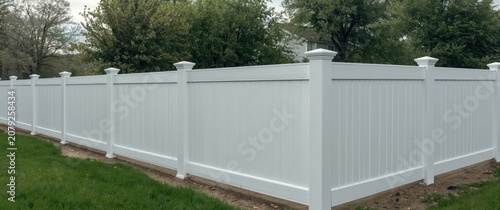White vinyl fence in a green yard
