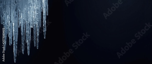 Icicles hanging from a dark...