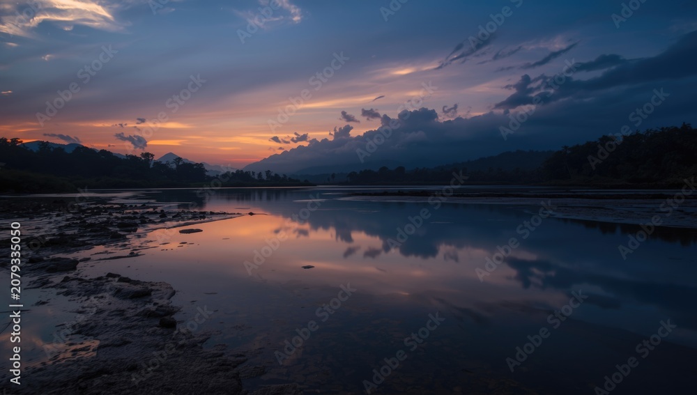 Fototapeta premium Twilight over a serene river with mountain reflections