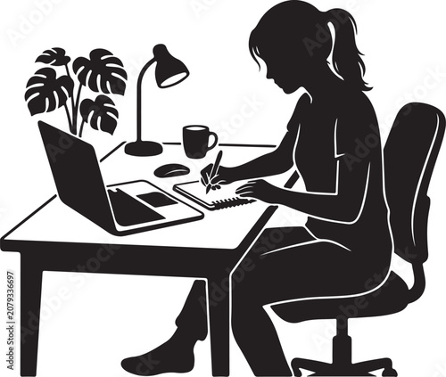 Woman sitting at desk working on laptop and writing in notebook