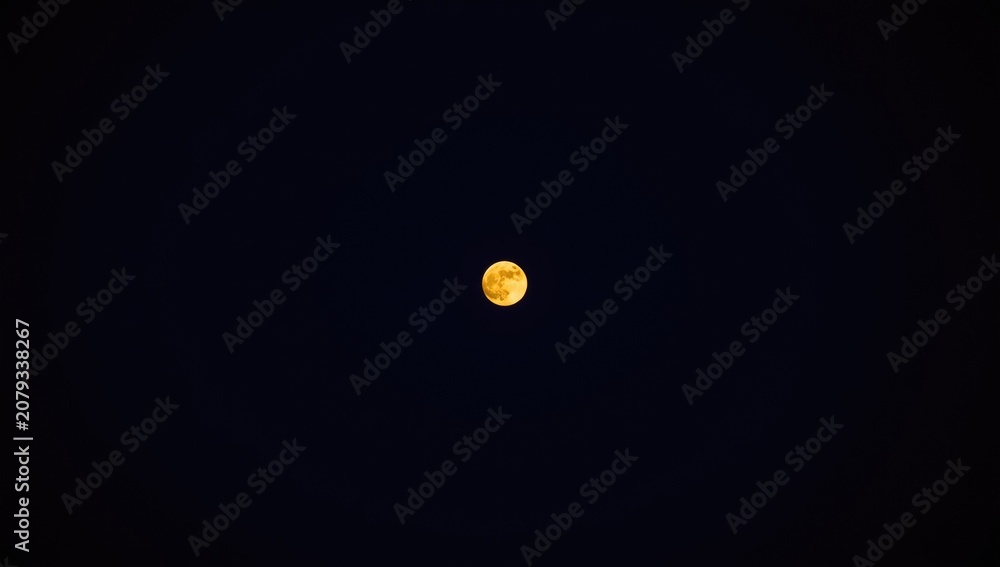 Fototapeta premium Full moon glowing against a dark night sky