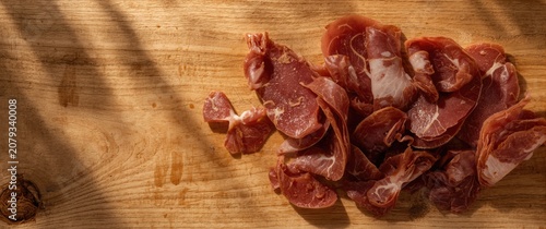 Sliced cured meat on a wood...