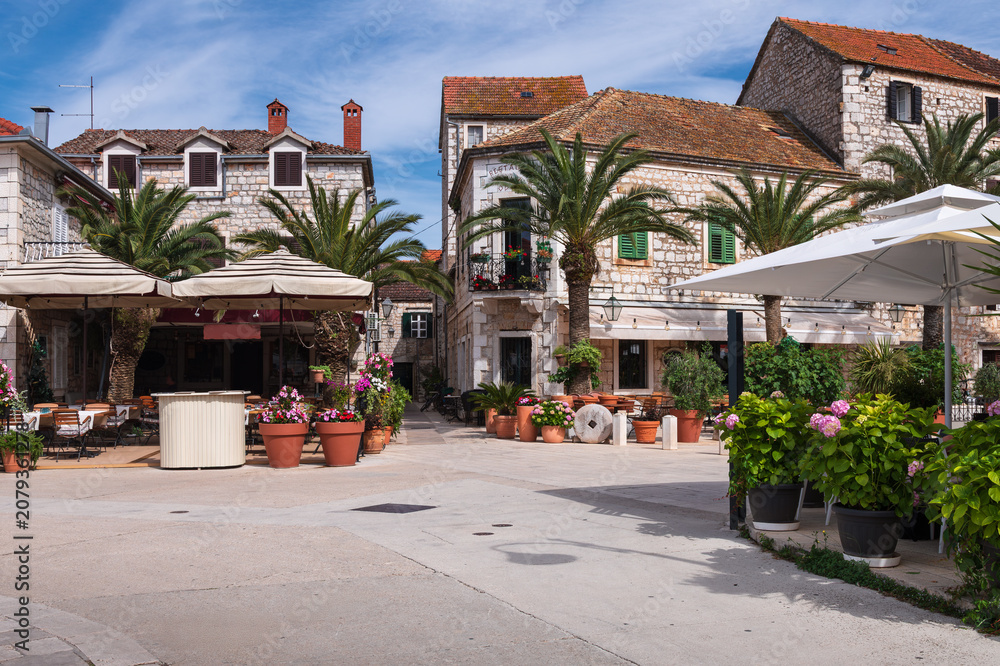 Obraz premium Cozy cafe terraces on old stone square in Jelsa town, Hvar island