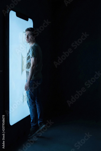 Conceptual Metaphor of a Young Man Consumed and Addicted to a Glowing Smartphone Screen