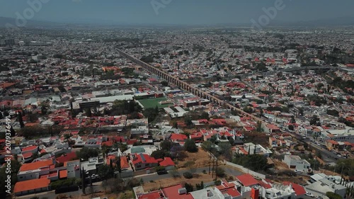 Aerial perspective of iconic stone arches defining Querétaro's historic district with gentle traffic flow and preserved colonial structures creating urban landscape