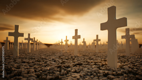 Rows of weathered grave markers stand across a vast field under a glowing sunset sky during a quiet evening moment of remembrance to honor those who have passed away during a historical conflict