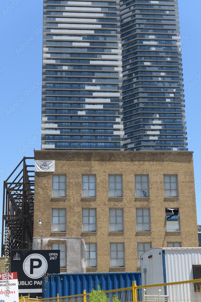 Obraz premium (brick building) former LCBO headquarters at 55 Lake Shore Blvd E and view of Sugar Wharf condominium complex towers, Toronto