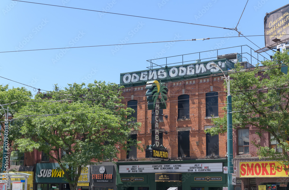 Obraz premium wide distant view of building facades and signs including El Mocambo a live music venue located at 464 Spadina Av, Toronto