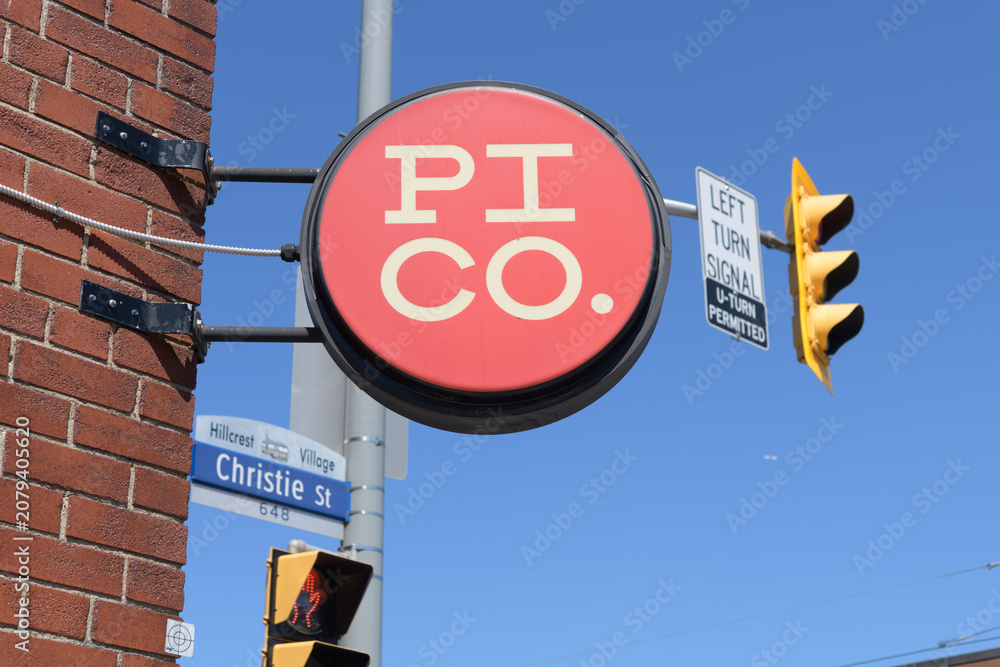 Obraz premium skyward view of wall-mounted round projecting sign outside Pi Co pizza southwest corner of Christie St and 687 St Clair Av W, Toronto