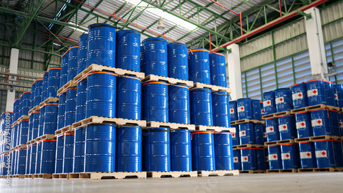Chemical drums with 200-liter capacity are stacked systematically on wooden pallet shelving in a warehouse, emphasizing logistics planning and safe chemical storage.
