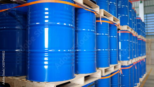 Chemical drums with 200-liter capacity are stacked systematically on wooden pallet shelving in a warehouse, emphasizing logistics planning and safe chemical storage.
