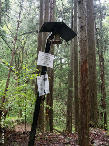 Panneau avec cloche pour avertissement et  mise en garde alerte danger contre l'ours au Japon dans la forêt