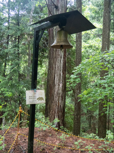 Panneau avec cloche pour avertissement et  mise en garde alerte danger contre l'ours au Japon dans la forêt