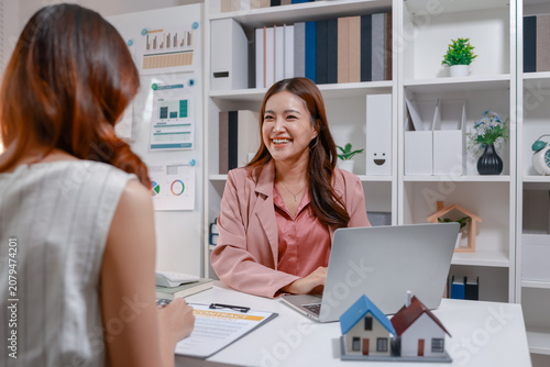 Fotografie Real estate consultant presenting a property purchase agreement and explaining contract terms, financing options, and home buying procedures to clients in a professional office