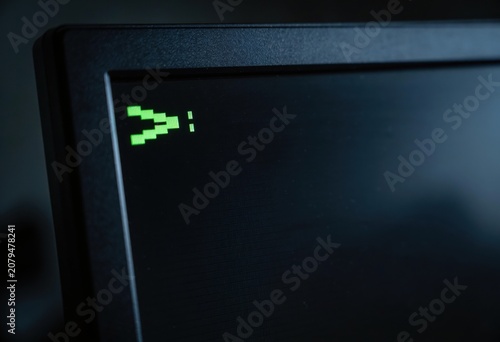 Green pixelated cursor on a dark computer screen display