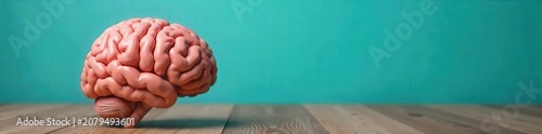 Human brain model on wooden table against turquoise background for neurology and medical research concepts