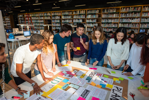 Bild auf Leinwand Diverse group of young adults collaborating around a design table