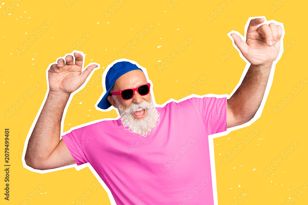 Naklejka premium Energetic senior man dancing in pink shirt and sunglasses on bright yellow background, playful retro portrait of a happy grandfather having fun and feeling youthful