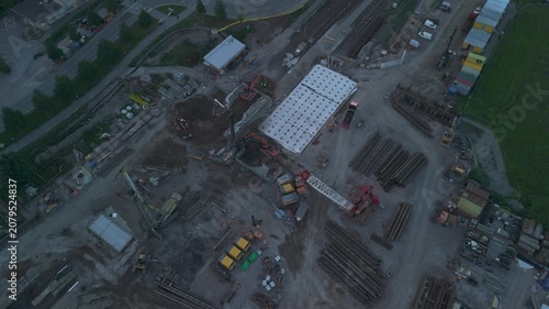 top down drone perspective of a construction project with heavy equipment cranes and excavation work documenting large scale urban development