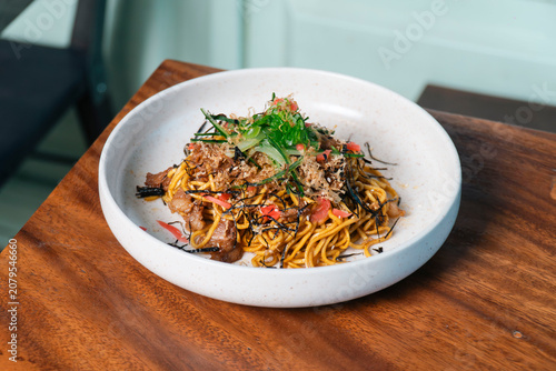 Slika na platnu A Culinary Masterpiece: Savor the rich flavors of this delectable noodle dish, a harmonious blend of textures and savory toppings, presented artfully in a pristine white bowl