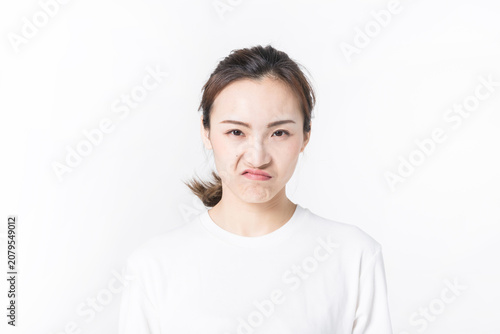 Tableau sur toile Young woman making a disgusted and annoyed facial expression on white background