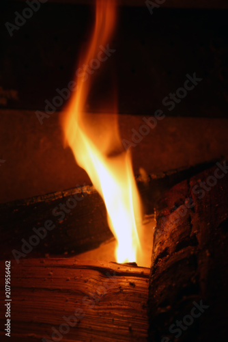 Burning wood with big red and orange flames. Fascinating abstract view symbolizing cooking, warmth, camping - and on the other hand burning, danger and hell. Closeup image.