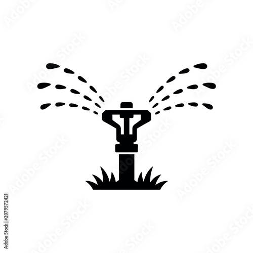 Black silhouette of a garden sprinkler spraying water on grass