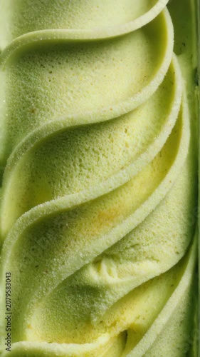 Macro shot of green swirled frozen dessert. Concept of sensory processing and repetitive thoughts. Close-up of pistachio ice cream texture
