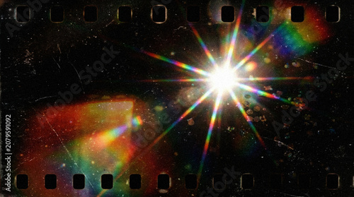 Obraz na płótnie Abstract dark vintage background with central rainbow starburst lens flare, 35mm film strip border with sprocket holes, heavy dust, and scratches for retro cinematic overlay