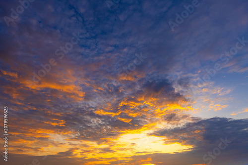 Dramatic Golden Sunset Sky with Vibrant Clouds,A breathtaking view of a dramatic golden sunset sky, filled with vibrant orange and yellow clouds scattered across a deep blue twilight atmosphere,