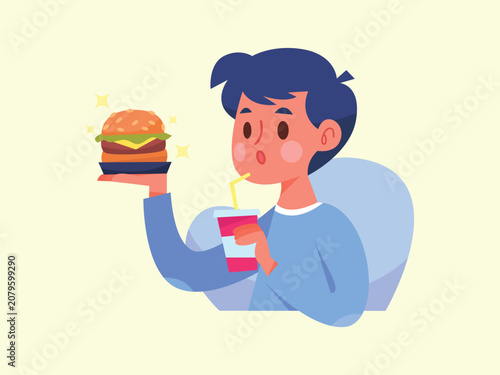 Young man eating delicious cheeseburger and drinking soda while relaxing.