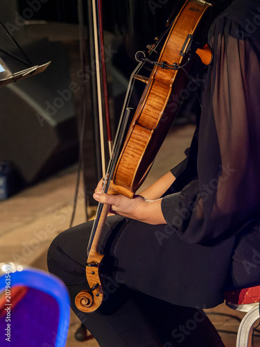 Photography Soft lighting highlights the musician's hands as he holds the viola while resting