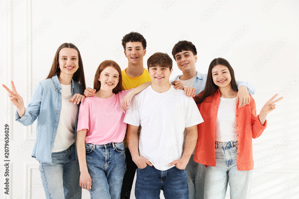 Obraz premium Portrait of happy teenagers near white wall indoors