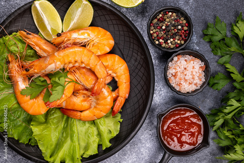 Boiled prawns serving on lettuce with lime and spices