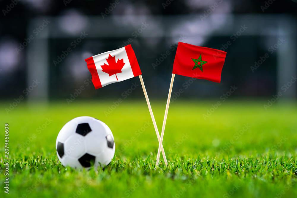 Fototapeta premium Canada vs Morocco, national flags before international football tournament Round of 16 match, football on green grass with stadium in the background, Houston, Texas, USA, July 4, 2026