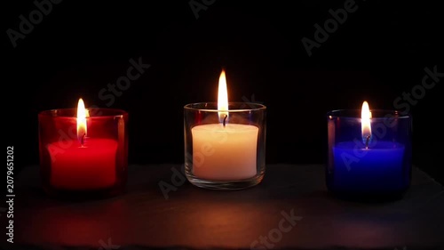 Three glowing candles in red, white, and blue colors, offering a warm and hopeful ambiance.